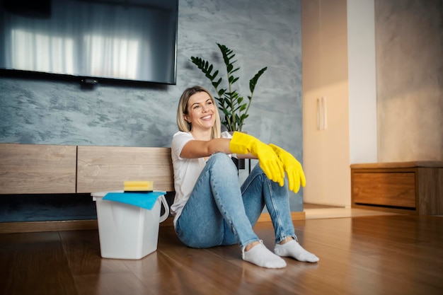 happy woman sits floor smiling because she finished all chores house is clean 232070 19024 4164050471