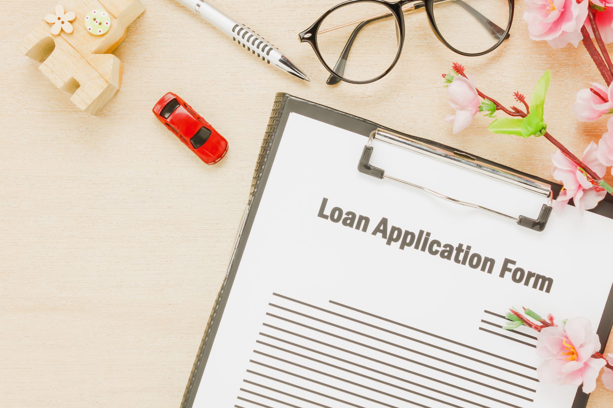 How Short-Term Loans Are Helping Americans Cover Emergencies top view business office desk background business loan appcation form pen flower house car wooden table background with copy space scaled